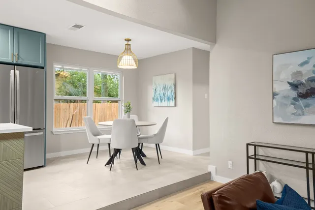 a dining room with furniture a chandelier and wooden floor