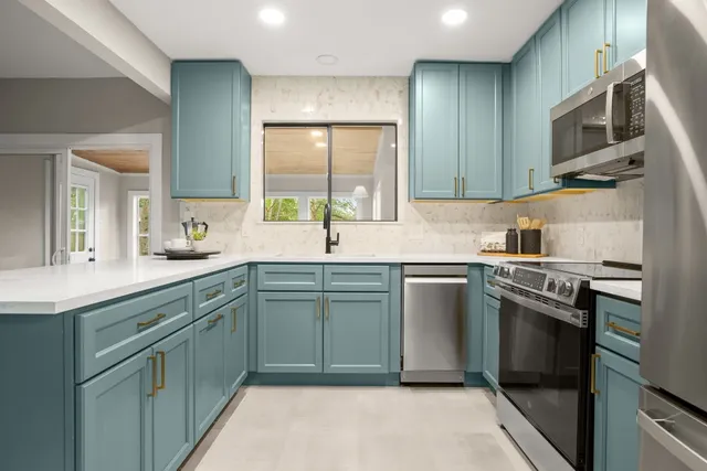 a kitchen with stainless steel appliances granite countertop a sink and stove top oven