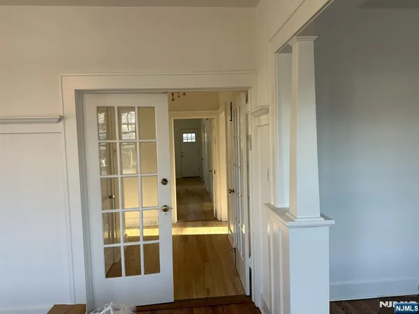 a view of a hallway with wooden floor and a bathroom