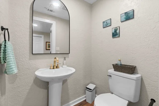 a bathroom with a toilet sink and mirror