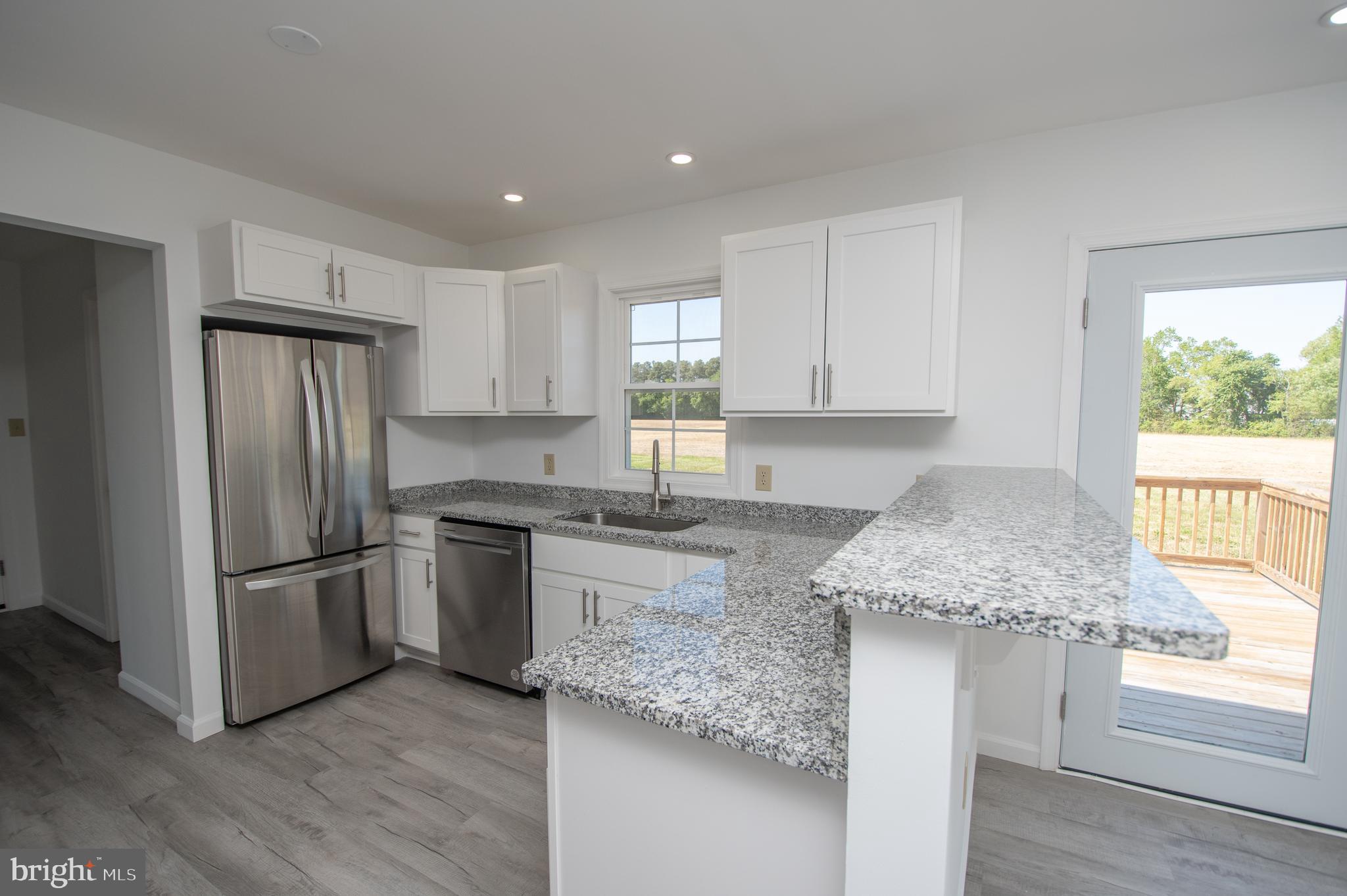 8707 Bacons Road Laurel, DE 19956 - Photo 5 of 18 a kitchen with stainless steel appliances granite countertop a sink stove and refrigerator