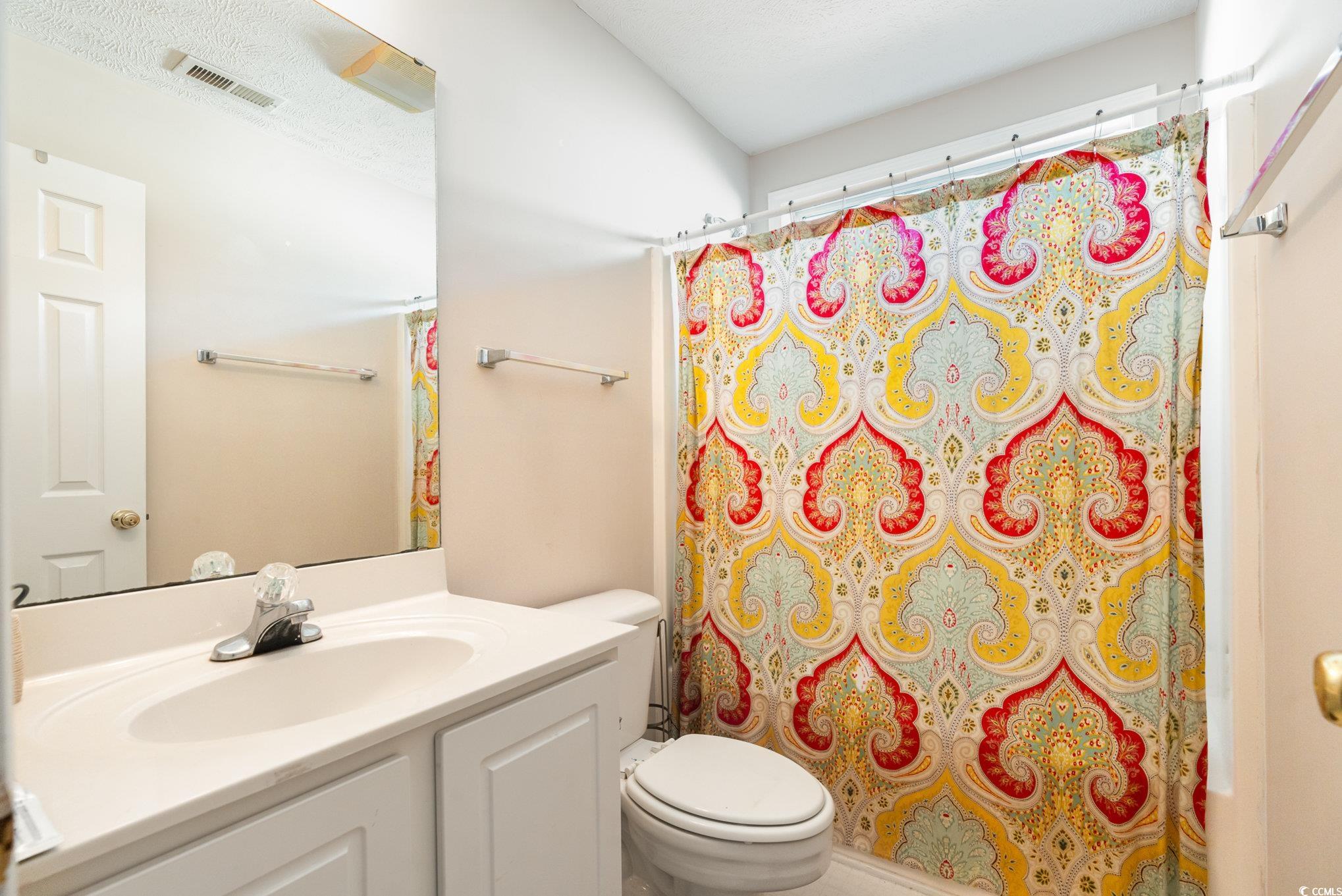 1005 Autumn Drive Murrells Inlet, SC 29576 - Photo 16 of 25 Bathroom with toilet, a textured ceiling, and vani
