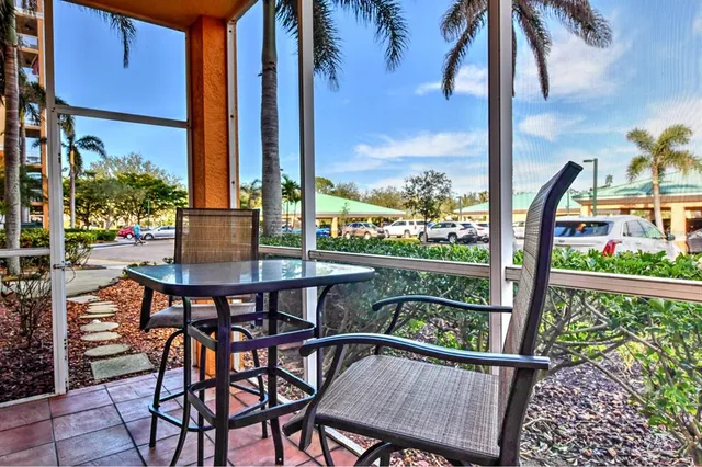 a balcony view with a glass top table and chairs