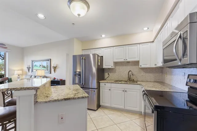a kitchen with stainless steel appliances granite countertop a refrigerator and a stove top oven