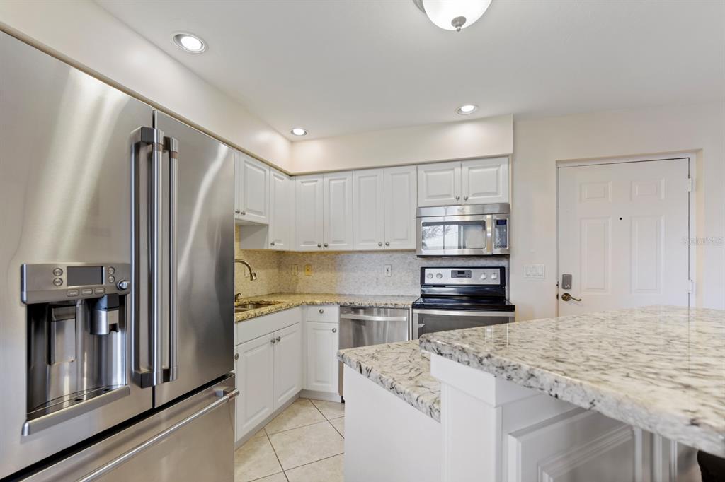 2060 Matecumbe Key Road, Unit 2107 Punta Gorda, FL 33955 - Photo 8 of 44 a kitchen with stainless steel appliances granite countertop a refrigerator and a stove top oven