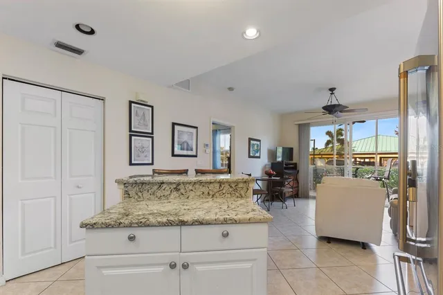 a living room with stainless steel appliances furniture and a kitchen view