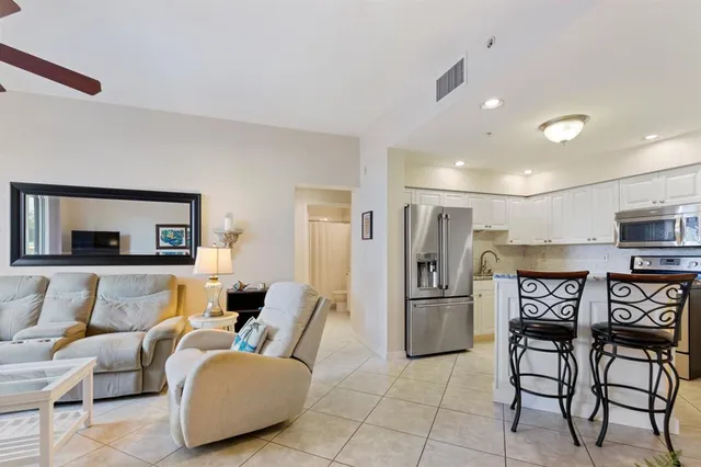 a kitchen with stainless steel appliances granite countertop sink refrigerator and cabinets