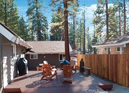 a view of a patio with table and chairs with wooden fence and floor