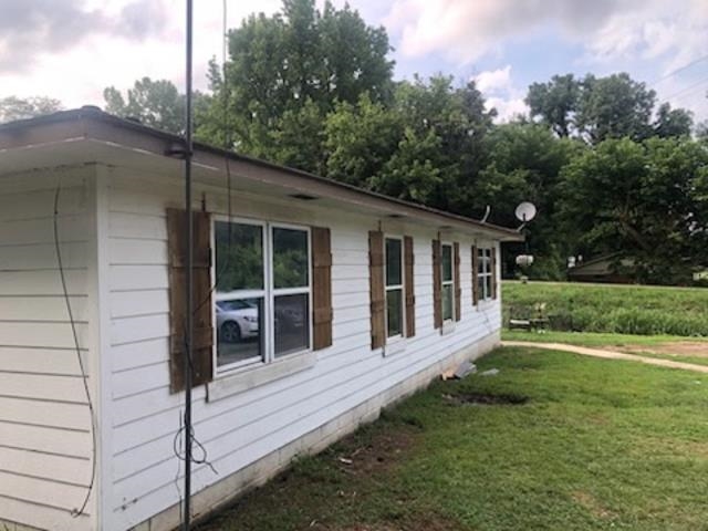 132 Stardust Drive Ripley, TN 38063 - Photo 8 of 10 White horizontal siding exterior with multiple windows featuring wood-finish shutters