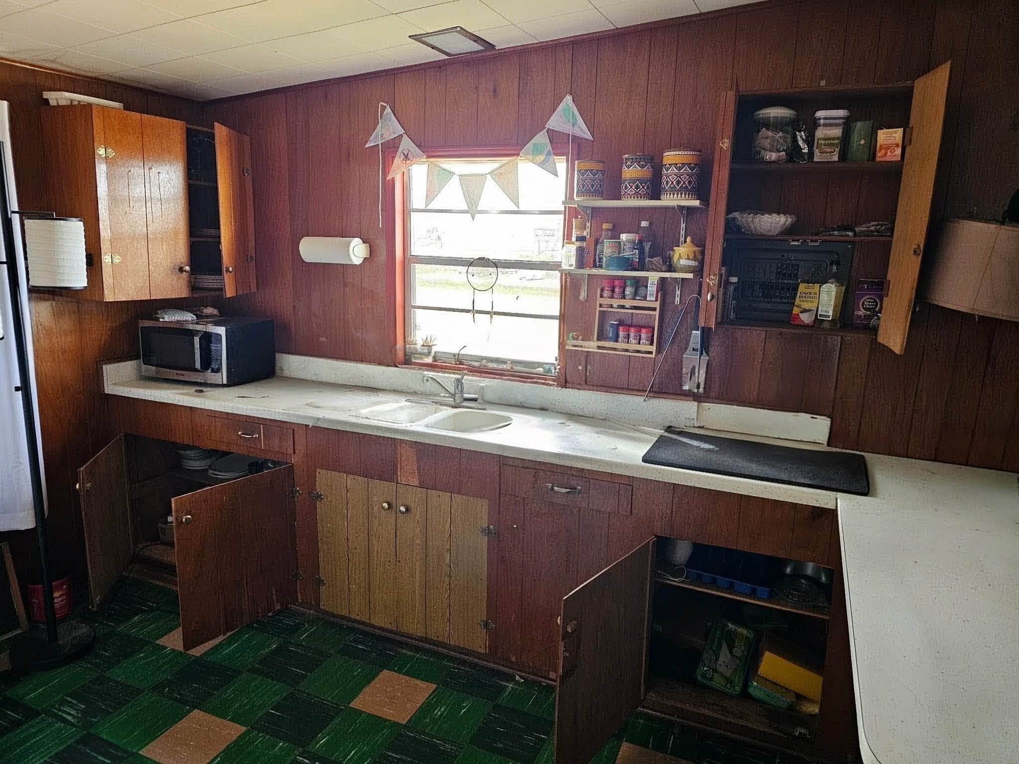 605 Texas Street Surfside Beach, TX 77541 - Photo 6 of 8 a kitchen with a sink cabinets and window