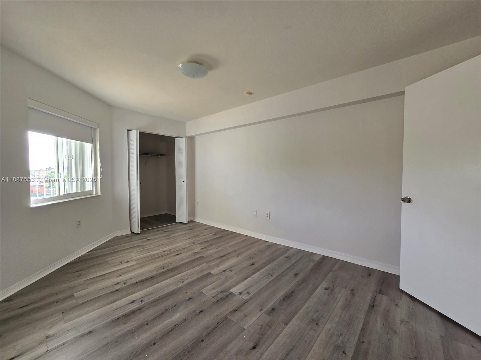 637 Southwest 3rd Street, Unit 404 Miami, FL 33130 - Photo 3 of 14 a view of an empty room with wooden floor and a window