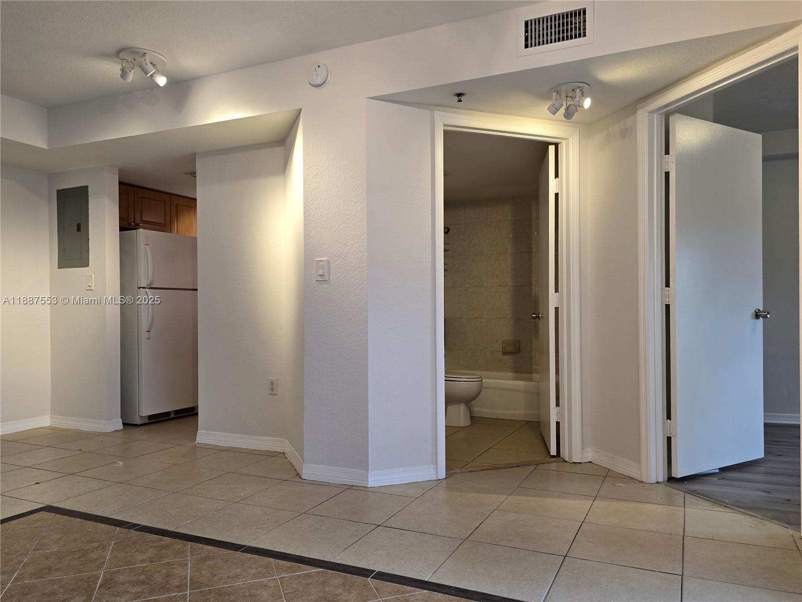 637 Southwest 3rd Street, Unit 404 Miami, FL 33130 - Photo 6 of 14 a view of a refrigerator in kitchen and an empty room