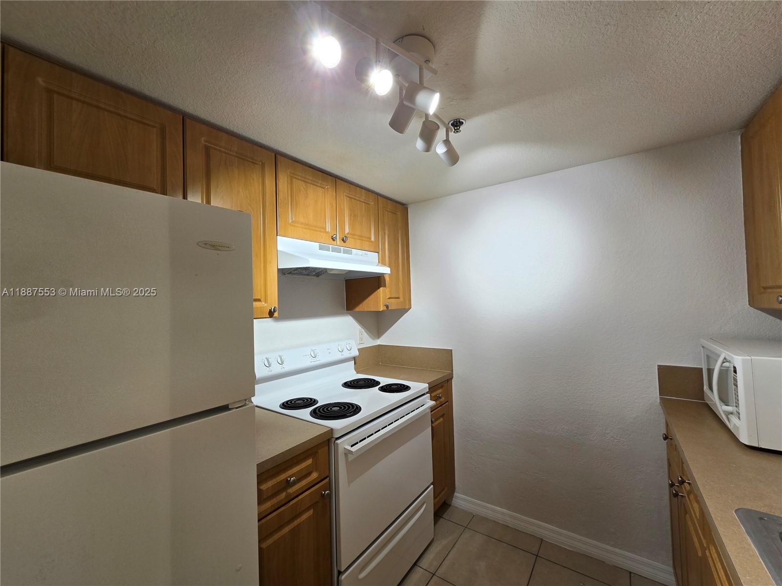 637 Southwest 3rd Street, Unit 404 Miami, FL 33130 - Photo 7 of 14 a kitchen with a stove and a refrigerator