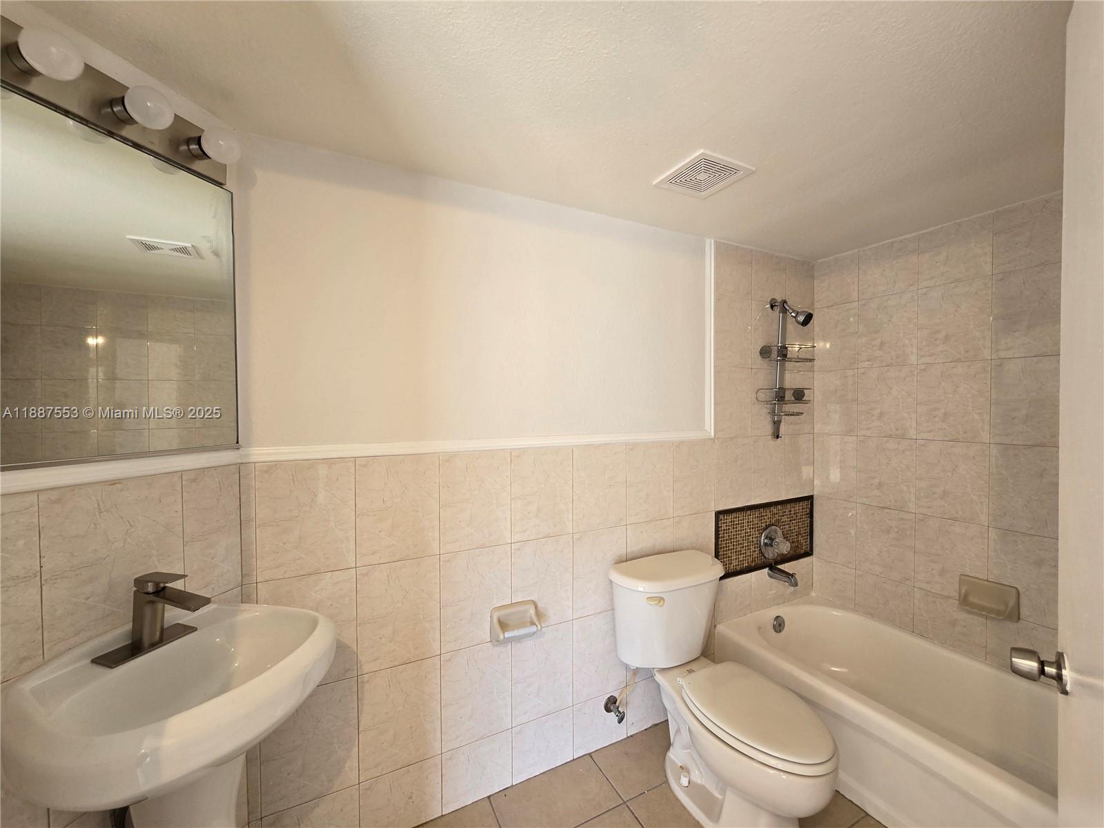 637 Southwest 3rd Street, Unit 404 Miami, FL 33130 - Photo 9 of 14 a bathroom with a bathtub shower sink vanity and toilet