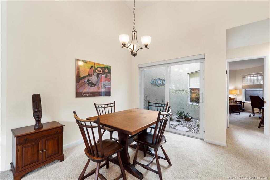 2437 Southwest Foxpoint Trail Palm City, FL 34990 - Photo 11 of 60 a view of a dining room with furniture wooden floor and a chandelier