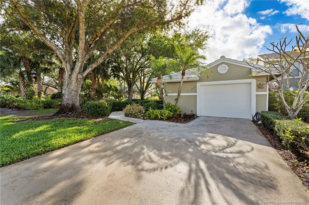 2437 Southwest Foxpoint Trail Palm City, FL 34990 - Photo 2 of 60 a view of a white house with a yard and plants