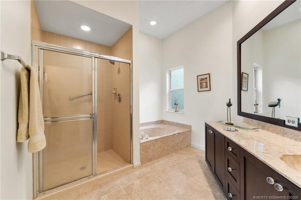 2437 Southwest Foxpoint Trail Palm City, FL 34990 - Photo 23 of 60 a spacious bathroom with a granite countertop sink mirror and shower