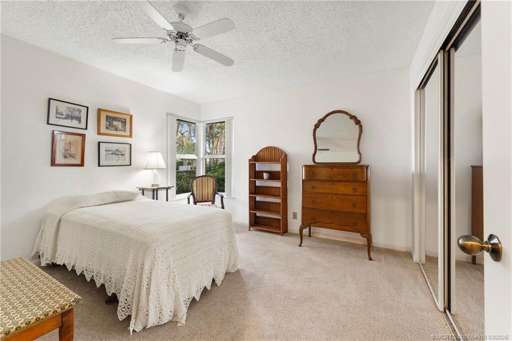 2437 Southwest Foxpoint Trail Palm City, FL 34990 - Photo 29 of 60 a bedroom with a bed and a chandelier