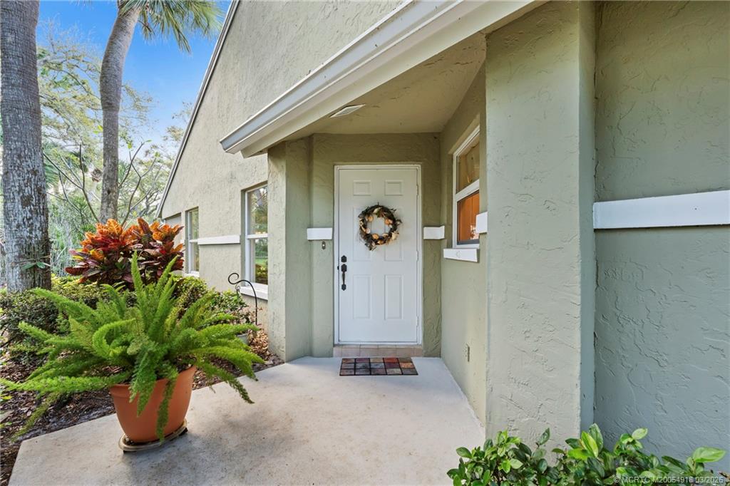 2437 Southwest Foxpoint Trail Palm City, FL 34990 - Photo 3 of 60 a potted plant in front of a door