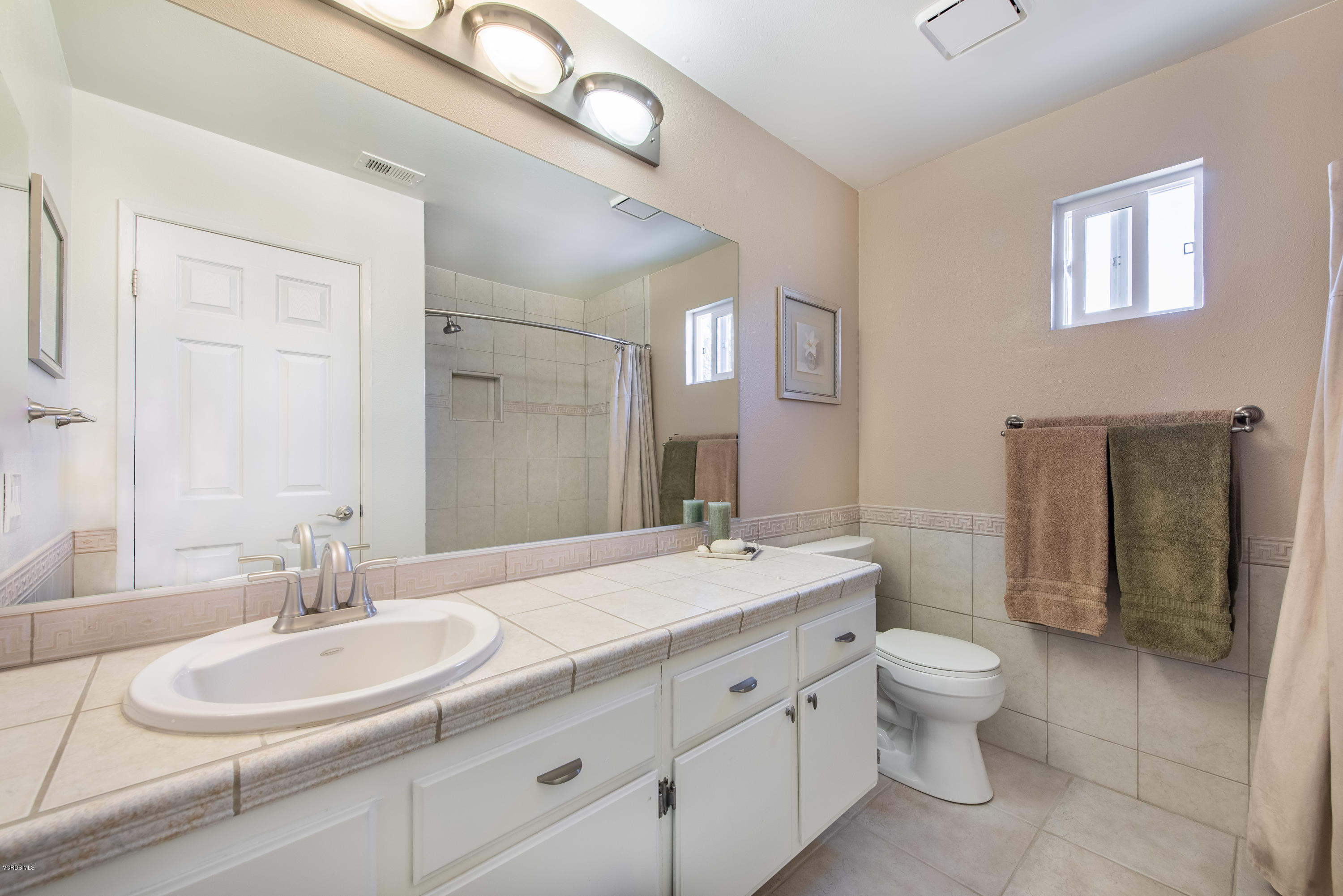 15430 Kernvale Avenue Moorpark, CA 93021 - Photo 13 of 16 a bathroom with a granite countertop double vanity sink a mirror and a toilet