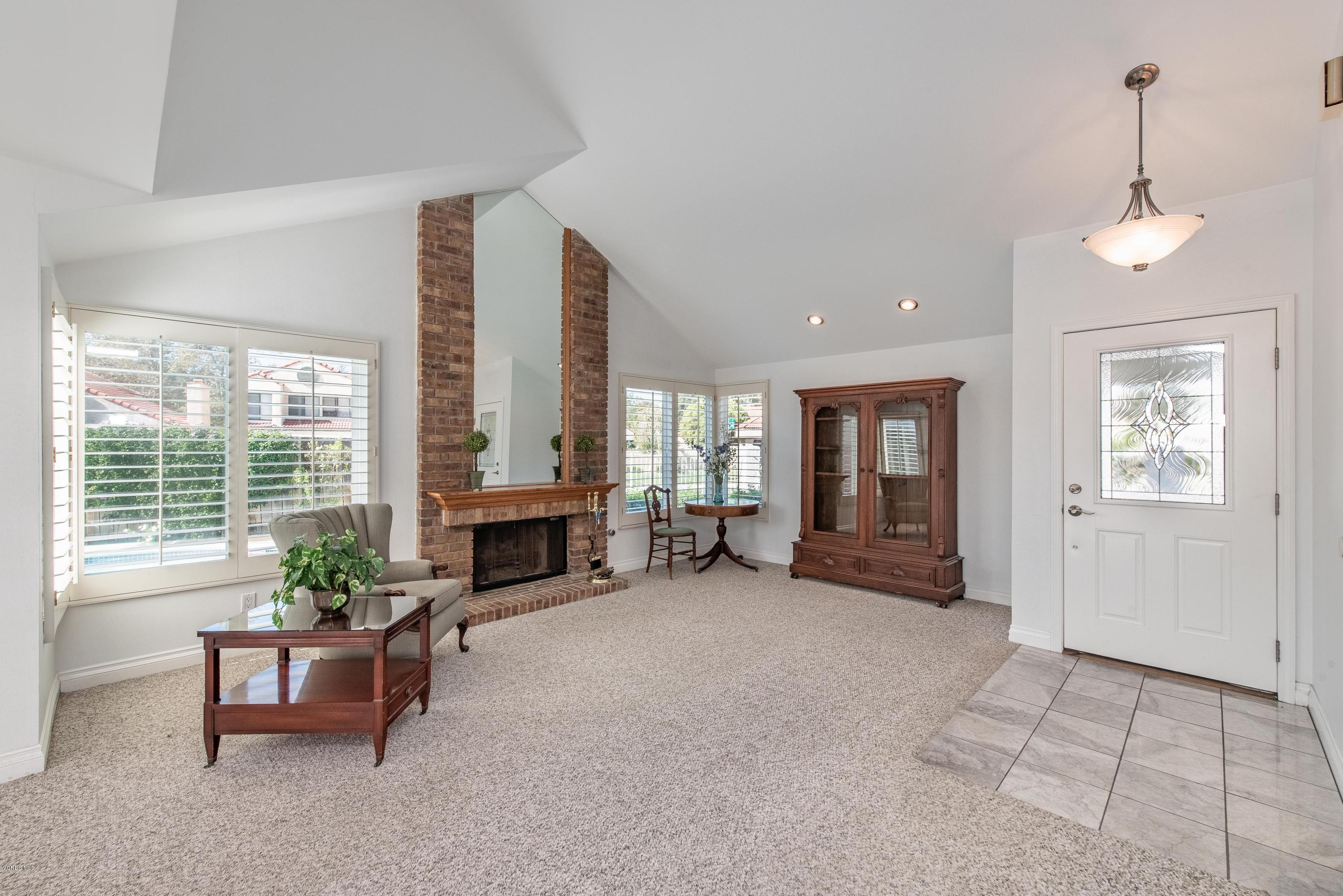 15430 Kernvale Avenue Moorpark, CA 93021 - Photo 3 of 16 a living room with furniture a fireplace and a large window
