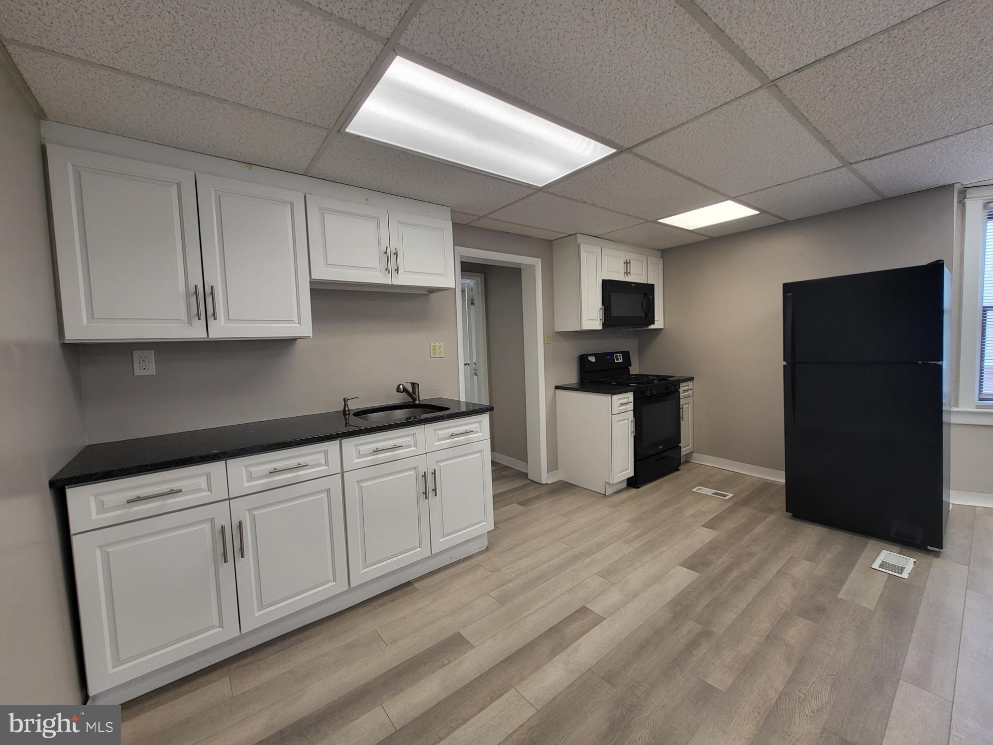 2114 Darby Road Havertown, PA 19083 - Photo 3 of 10 a kitchen with granite countertop white cabinets and refrigerator