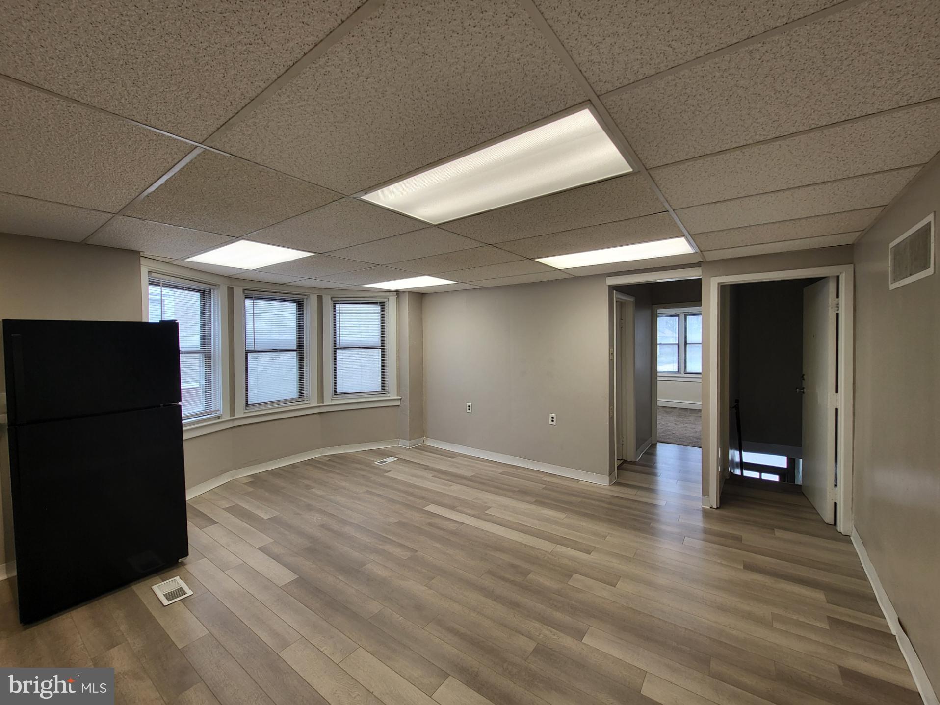 2114 Darby Road Havertown, PA 19083 - Photo 4 of 10 a view of an empty room with window and wooden floor