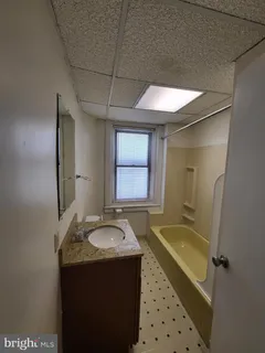 a bathroom with a granite countertop sink a mirror and a bathtub