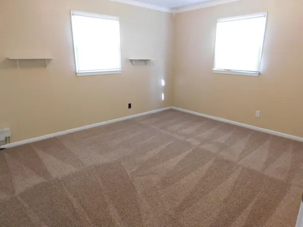 a view of an empty room with a wooden floor and a window