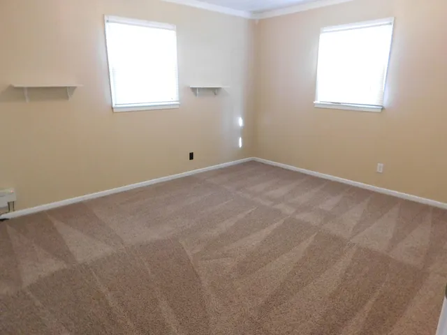 a view of an empty room with a wooden floor and a window