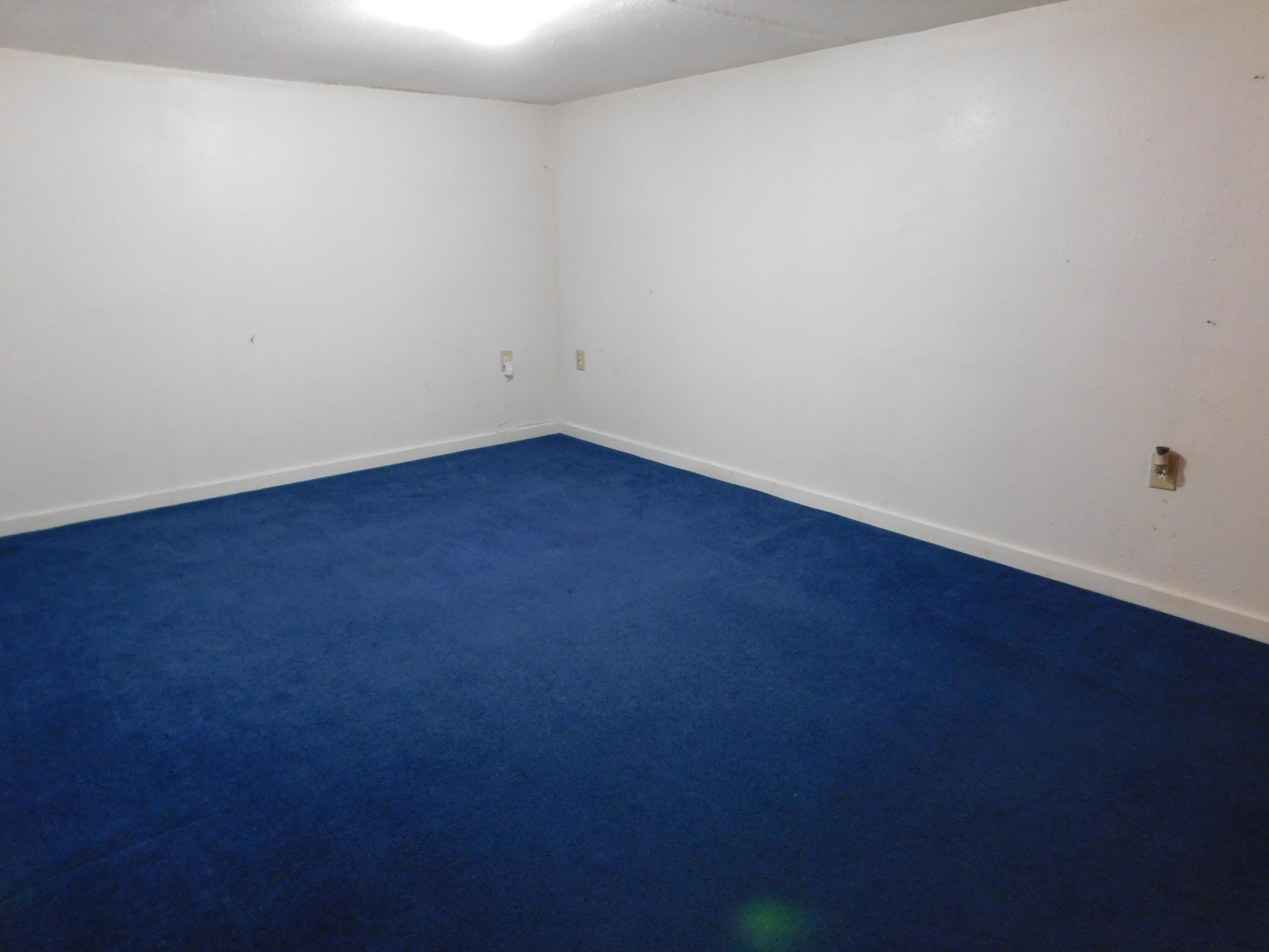 1722 West Ave B Muleshoe, TX 79347 - Photo 14 of 20 an empty room with wooden floor and windows