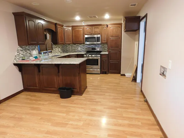 a kitchen with stainless steel appliances granite countertop wooden cabinets a oven and granite counter tops