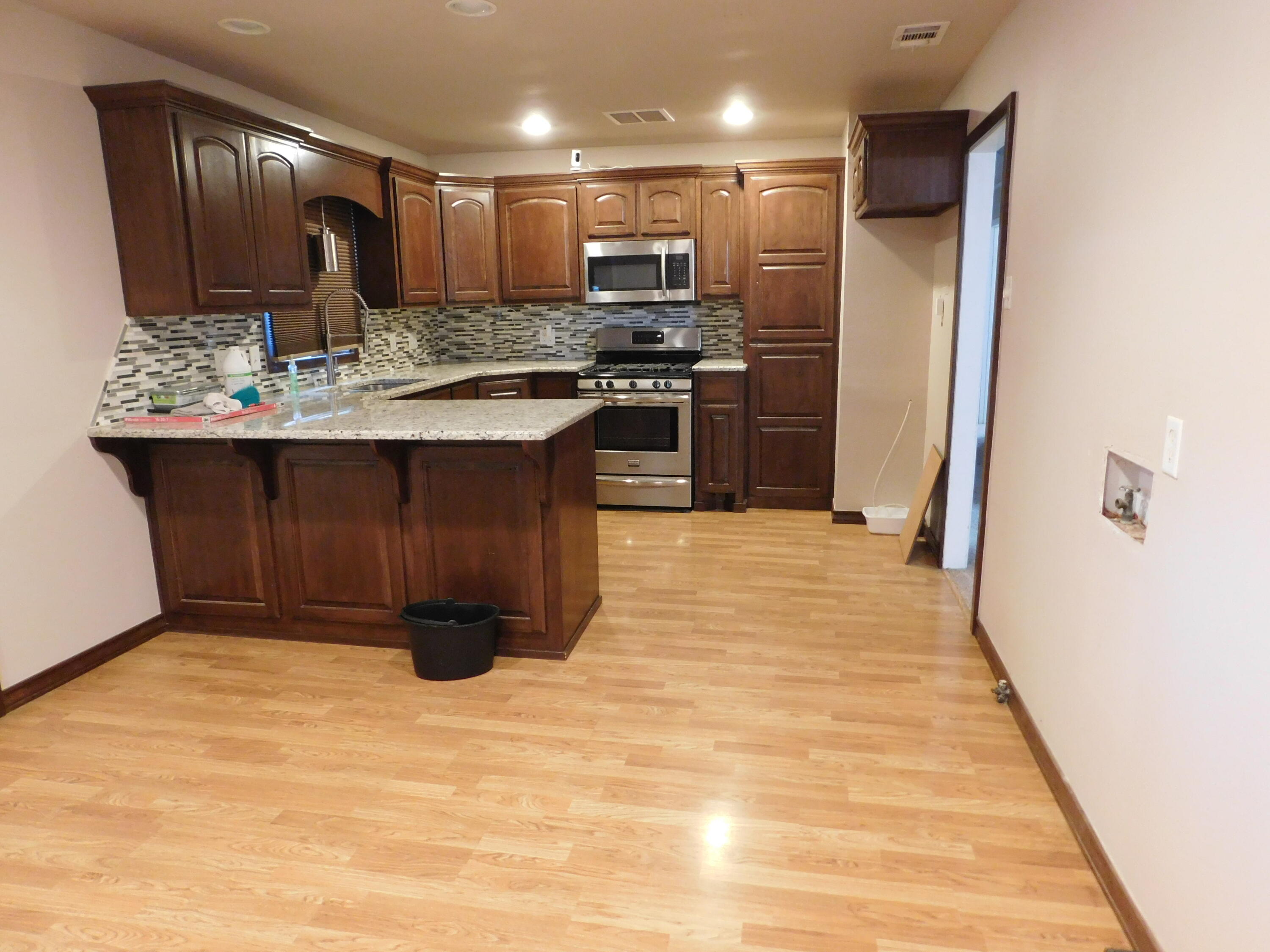 1722 West Ave B Muleshoe, TX 79347 - Photo 5 of 20 a kitchen with kitchen island granite countertop wooden cabinets a refrigerator stove a sink and dishwasher