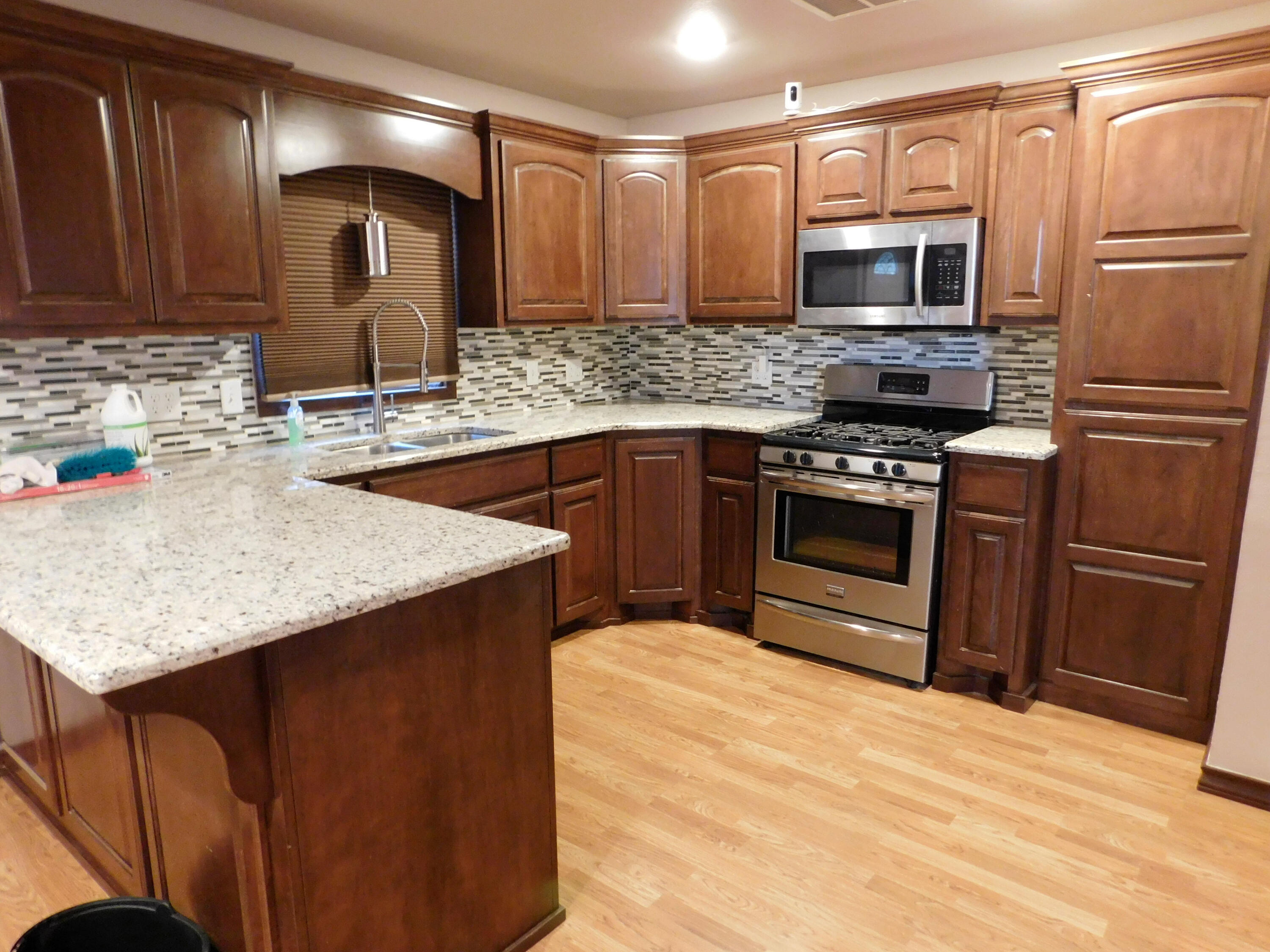 1722 West Ave B Muleshoe, TX 79347 - Photo 6 of 20 a kitchen with stainless steel appliances granite countertop a sink stove microwave and refrigerator