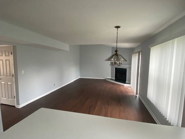 209 North Southport Road Mundelein, IL 60060 - Photo 8 of 18 an empty room with wooden floor fireplace and windows