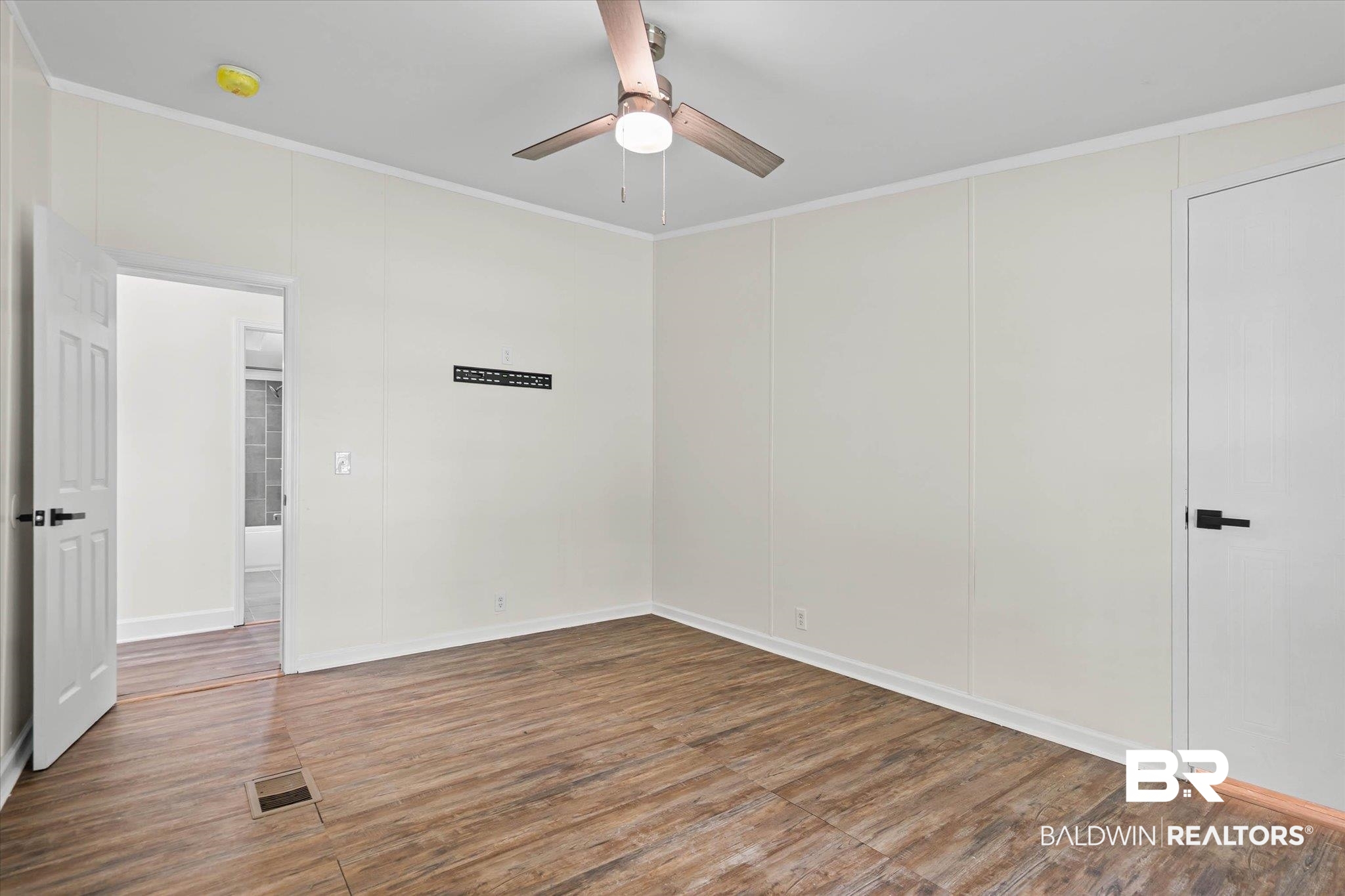 9230 McLeod Road Mobile, AL 36695 - Photo 15 of 20 Interior space featuring wood-finish flooring, white panel walls, and a ceiling fan with integrated lighting
