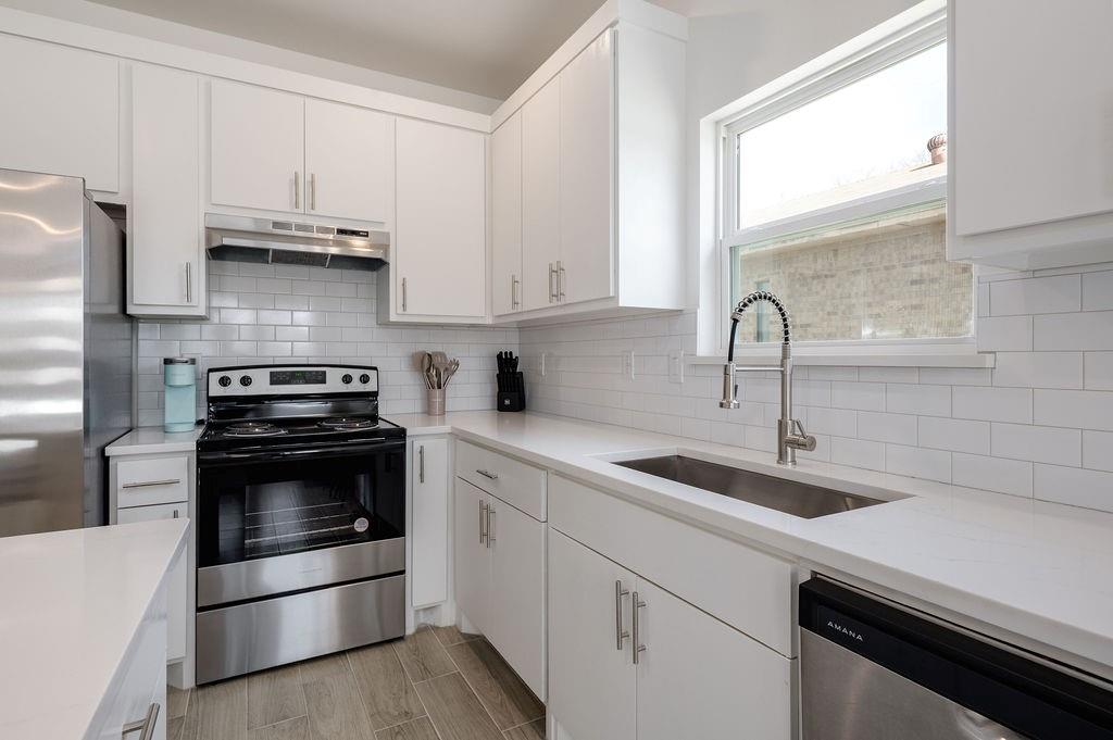 709 Fuller Street Sulphur Springs, TX 75482 - Photo 11 of 22 a kitchen with granite countertop a sink stainless steel appliances and cabinets