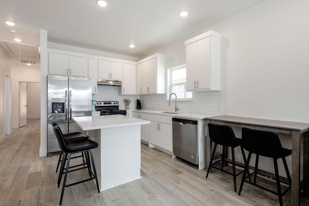 709 Fuller Street Sulphur Springs, TX 75482 - Photo 9 of 22 a kitchen with a table chairs microwave and cabinets