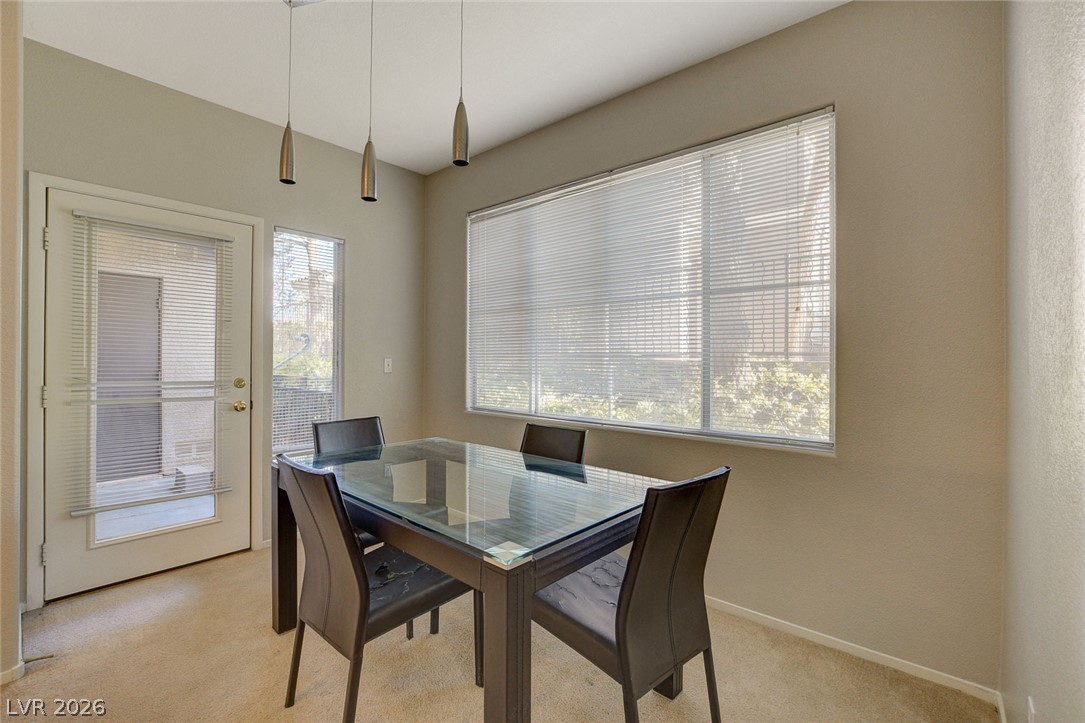 9050 West Warm Springs Road, Unit 1034 Las Vegas, NV 89148 - Photo 7 of 17 A dining space with elegant pendant lighting and a wide window provides a luminous setting for meals.