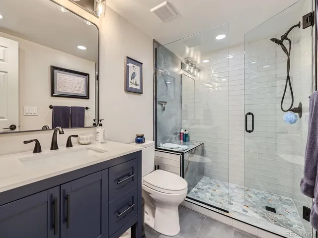 a bathroom with a sink toilet a mirror and shower