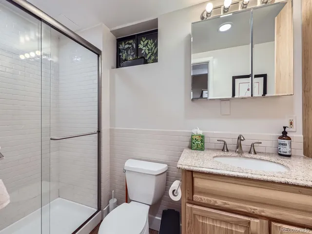 a bathroom with a granite countertop sink toilet and shower