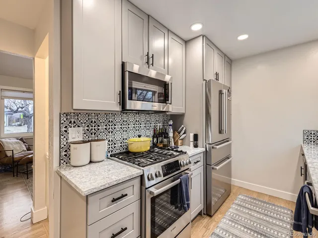a kitchen with stainless steel appliances a stove a sink and a refrigerator