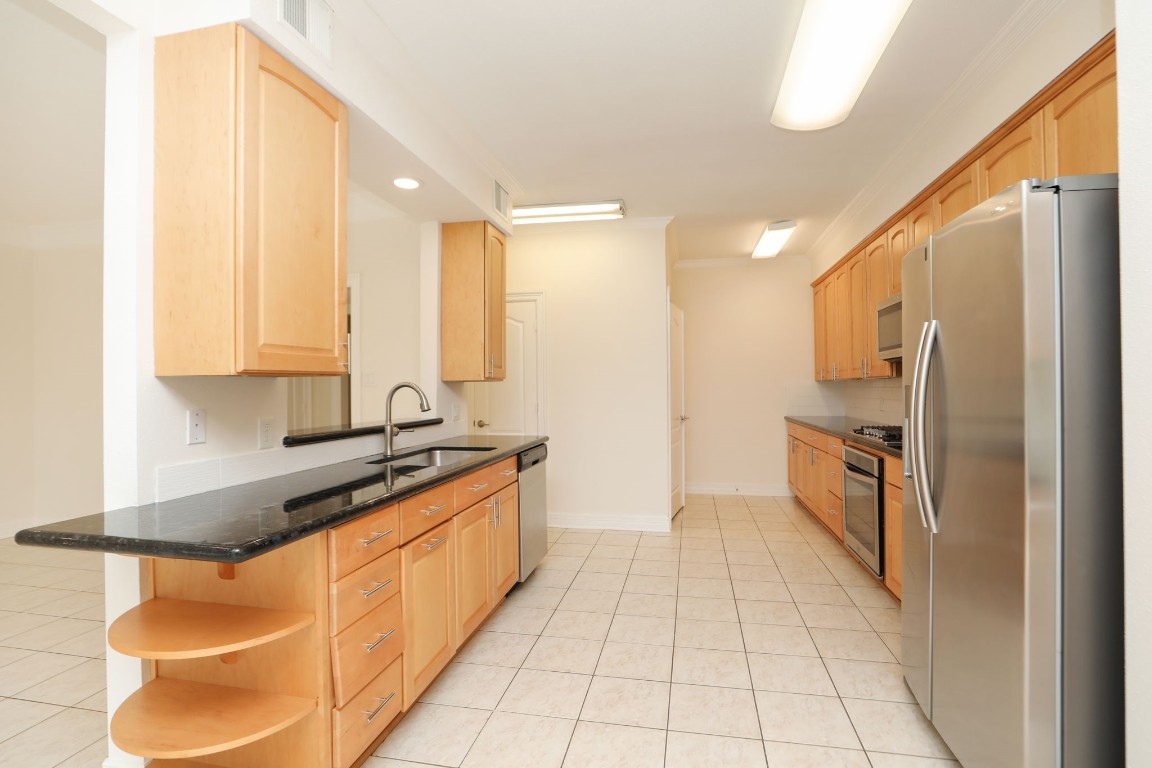 7499 Brompton Street, Unit 7499 Houston, TX 77025 - Photo 17 of 43 a kitchen with stainless steel appliances granite countertop a stove a sink and a refrigerator