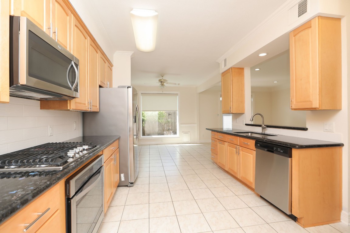 7499 Brompton Street, Unit 7499 Houston, TX 77025 - Photo 20 of 43 a large kitchen with stainless steel appliances granite countertop a stove and a sink