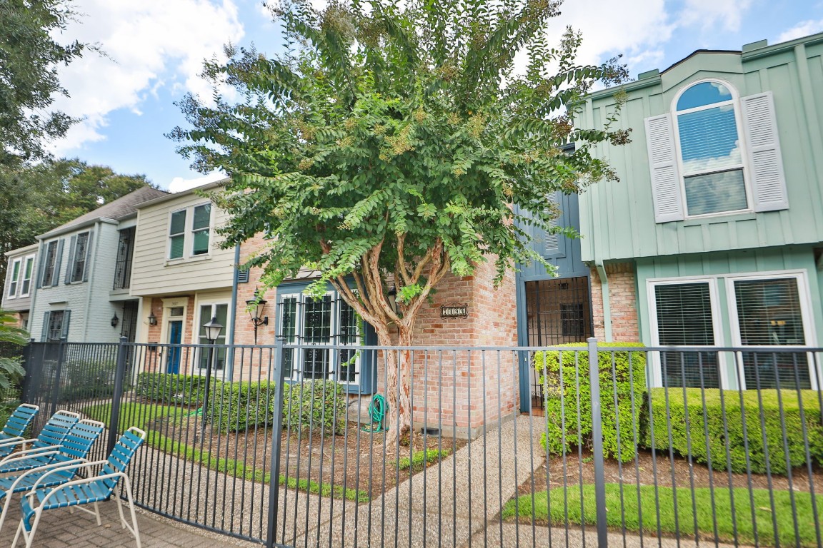 7499 Brompton Street, Unit 7499 Houston, TX 77025 - Photo 39 of 43 a view of a brick house with large windows and a flower plants