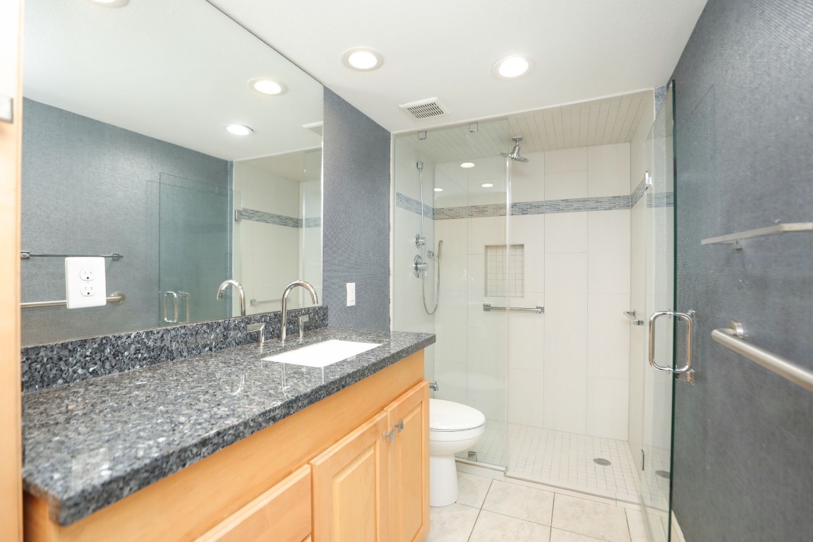 7499 Brompton Street, Unit 7499 Houston, TX 77025 - Photo 8 of 43 a bathroom with a granite countertop sink mirror vanity and toilet
