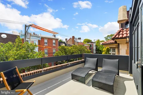 a front view of a house with a tree
