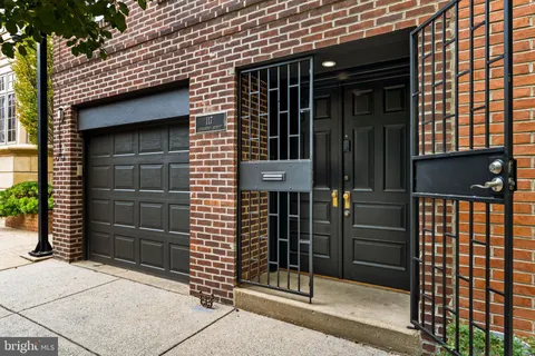 a view of a hallway with wooden floor and a bathroom
