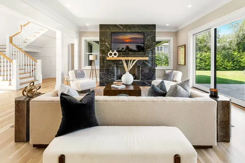 a living room with furniture a flat screen tv and a floor to ceiling window