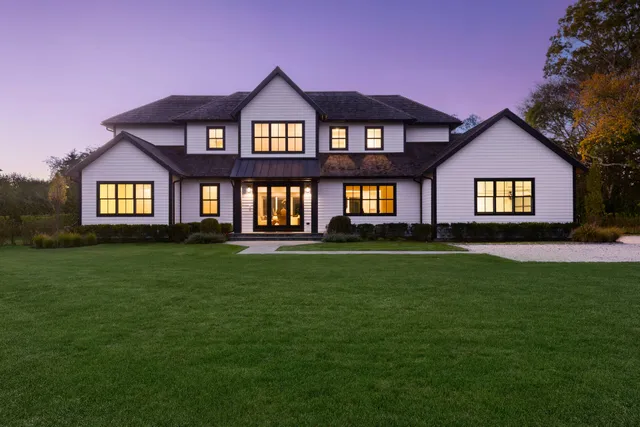 a front view of a house with a yard and trees